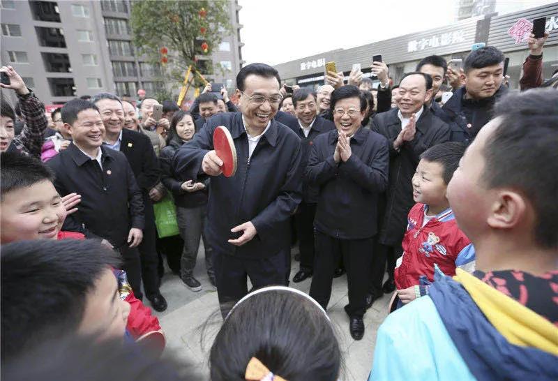 图为李克强在贵阳考察时，一群孩子围住总理“邀约”打乒乓球。